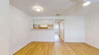Located at 5009 S West Shore Blvd in Tampa, Florida, this one-bedroom unit offers a thoughtfully arranged single-floor layout with a clean, modern aesthetic. Light-toned hardwood flooring runs continuously throughout the space, creating a warm and cohesive feel that enhances the airy, bright atmosphere.

The living area is open and versatile, anchored by a ceiling fan overhead and a textured ceiling. A pass-through counter connects the living space to the kitchen, which features white cabinetry, a natural wood-toned countertop, and a window that draws in natural light — making the area feel open and functional despite its compact footprint.

The bedroom is generously sized and benefits from a ceiling fan, two closets including a standard closet door configuration, and direct access to the bathroom. An in-unit stacked washer and dryer is conveniently tucked into the bedroom area, adding practical value. White walls and bright white trim are consistent throughout, lending the space a fresh, well-maintained appearance.

A window near the front entry allows additional natural light to fill the entryway, which also features a modern keypad door lock. The layout, as seen in the dollhouse view, flows logically from entry to living area, kitchen, bedroom, and bath — making efficient use of every square foot.