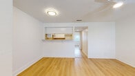 Located at 5009 S West Shore Blvd in Tampa, Florida, this one-bedroom unit offers a thoughtfully arranged single-floor layout with a clean, modern aesthetic. Light-toned hardwood flooring runs continuously throughout the space, creating a warm and cohesive feel that enhances the airy, bright atmosphere.

The living area is open and versatile, anchored by a ceiling fan overhead and a textured ceiling. A pass-through counter connects the living space to the kitchen, which features white cabinetry, a natural wood-toned countertop, and a window that draws in natural light — making the area feel open and functional despite its compact footprint.

The bedroom is generously sized and benefits from a ceiling fan, two closets including a standard closet door configuration, and direct access to the bathroom. An in-unit stacked washer and dryer is conveniently tucked into the bedroom area, adding practical value. White walls and bright white trim are consistent throughout, lending the space a fresh, well-maintained appearance.

A window near the front entry allows additional natural light to fill the entryway, which also features a modern keypad door lock. The layout, as seen in the dollhouse view, flows logically from entry to living area, kitchen, bedroom, and bath — making efficient use of every square foot.