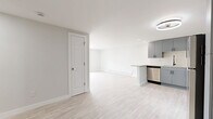 Located at 12155 W 58th Pl in Arvada, Colorado, this thoughtfully updated 2-bedroom, 2-bathroom unit offers a clean, modern aesthetic across a single floor. Light hardwood-style flooring flows throughout the space, complementing a bright, neutral color palette that enhances the overall sense of openness.

The kitchen is a standout feature, showcasing slate-blue cabinetry with matte black hardware, granite countertops, a subway tile backsplash, and a full suite of stainless steel appliances including a refrigerator, range, microwave, and dishwasher. A peninsula with a breakfast bar creates a natural connection to the adjacent living room, which offers generous open space and access to a large sliding glass door with vertical blinds, allowing for ample natural light.

The primary bedroom is a well-proportioned room with a window, baseboard heating, and a wall-mounted climate control unit. The second bedroom is comparably sized and similarly appointed. Three closets throughout the unit provide practical storage solutions.

Both bathrooms are finished with crisp white large-format tile, featuring tub-shower combinations with rainfall-style showerheads and matte black fixtures, paired with sleek gray vanities and white countertops. The overall design is cohesive, modern, and move-in ready.