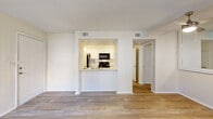 This 2-bedroom, 1-bathroom residence offers a thoughtfully designed single-floor layout that maximizes functionality and comfort. Light-toned hardwood-style flooring flows consistently throughout the home, creating a cohesive and airy atmosphere.

The living room serves as the heart of the space, featuring a tile-surround fireplace, a ceiling fan with lighting, and a sliding glass door that opens to an outdoor balcony, filling the room with natural light. A large wall mirror further enhances the sense of openness.

The kitchen is accessed via a pass-through peninsula counter finished in granite, which also functions as a breakfast bar. White shaker-style cabinetry, a subway tile backsplash, black appliances including a gas range and built-in microwave, and a stainless steel sink complete the kitchen.

Both bedrooms are generously proportioned, each equipped with a ceiling fan. The primary bedroom connects conveniently to the hallway, while the second bedroom features a window with natural light. The full bathroom includes a tiled shower-tub combination with a clean, all-white finish.

A dedicated laundry room houses a full-size washer and dryer alongside built-in shelving and an additional granite-topped counter, offering practical utility space.