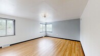 Located at 1201 Heeney Avenue in Johnstown, PA, this single-floor, three-bedroom, one-bathroom home offers a clean and functional layout with consistent modern finishes throughout. Light wood-look flooring runs across all rooms, complemented by crisp white walls, bold dark baseboards, and flush-mount circular light fixtures that lend a cohesive, updated aesthetic.

The living room is a generously sized, open area featuring corner windows that invite natural light and a modern ceiling fan fixture. The space connects via hallways to the rest of the home, providing a logical and accessible flow. The kitchen is positioned conveniently within the layout.

The three bedrooms each continue the wood flooring and neutral color scheme. The primary bedroom is the largest, featuring dual corner windows that fill the room with natural light. The additional bedrooms are well-proportioned, each with windows and access to one of the home's five closets — providing ample storage throughout.

The bathroom is bright and clean, featuring a full soaking tub with shower surround, a toilet, wood-look flooring, and a window for natural ventilation. Two utility rooms and two hallways round out the layout, adding practicality. The home's consistent finishes and well-distributed storage make it a functional and move-in ready residence.