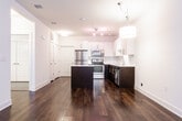 This two-story residence in Denville, NJ offers a thoughtfully designed layout with contemporary finishes throughout. The main level showcases rich, dark hardwood flooring that extends through the open-concept living and dining areas, where multiple windows allow ample natural light to fill the space. A pendant light fixture anchors the dining area, while a staircase with wood treads connects both floors. The modern kitchen is a standout feature, equipped with stainless steel appliances, a center island with a white quartz countertop, two-tone cabinetry with crisp white upper cabinets and dark lower cabinets, a classic subway tile backsplash, and track lighting overhead. A convenient half bath on the main level features a pedestal sink, wood-look tile flooring, and a window that brings in natural light. A full bathroom with a tub-shower combination, mosaic tile accent border, dark vanity cabinetry, and wood-look tile floors serves additional needs. The upper level features carpeted bedrooms with angled ceilings, built-in closets, and windows overlooking the surrounding neighborhood. A private en-suite bathroom on this level includes a glass-enclosed stand-up shower with a decorative tile accent, complementing the home's consistent, modern aesthetic throughout.