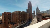 This rooftop space delivers an exceptional urban experience, combining expansive open-air areas with well-appointed interior access points in the heart of a vibrant downtown setting. The outdoor deck is finished with composite decking and lined with sturdy decorative railings, providing a secure and visually polished perimeter. Panoramic views of the surrounding cityscape are a defining feature, with iconic mid-rise and high-rise buildings visible in every direction beneath wide-open skies.

Access to the rooftop is facilitated through a clean, well-lit interior corridor lined with large black-framed windows that frame city views and flood the space with natural light. The corridor features light-toned tile flooring with subtle penny-tile accent borders, lending a refined, modern aesthetic. A paneled entry door with brushed nickel hardware opens into a foyer area distinguished by a decorative tile inset, offering a polished transition between interior and exterior.

Interior walls are finished in crisp white with clean baseboard trim, maintaining a bright, neutral palette throughout. The overall design balances a minimalist, contemporary interior with the dynamic energy of the outdoor rooftop environment. Whether used as a private retreat or a shared amenity, this rooftop space provides a compelling connection to the surrounding urban landscape.