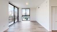 This contemporary apartment in Miami offers a well-designed living space of 780 square feet. The unit features three bedrooms, including a primary bedroom of 120 square feet, and four bathrooms, providing ample space and privacy for residents and guests. The open-concept layout seamlessly integrates the kitchen and living room, creating a spacious feel.

The kitchen is a highlight, boasting modern light wood cabinetry, stainless steel appliances, and a clean white backsplash. Track lighting and recessed fixtures illuminate the space effectively. Large windows dominate the living areas and bedrooms, flooding the apartment with natural light and offering breathtaking views of the Miami skyline and surrounding cityscape.

Throughout the apartment, warm-toned hardwood flooring adds a touch of elegance and continuity. The bathrooms feature sleek designs with modern fixtures, including a bathtub in at least one of the bathrooms. A built-in closet provides additional storage space.

The apartment's neutral color palette, predominantly white walls, and minimalist design create a fresh and airy ambiance. This turnkey property, located at 450 SW 5th St in Miami, combines urban sophistication with comfortable living, making it an ideal residence in the heart of the city.