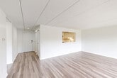 This well-appointed one-bedroom, one-bathroom residence in Belmont, MA offers a clean, modern aesthetic across its efficiently designed single-floor layout. Light wood-style flooring runs continuously throughout, creating a cohesive and contemporary feel. The open-concept living and dining area is bright and airy, with white walls that maximize the sense of space. A pass-through window connects the living area to the kitchen, enhancing the open flow between rooms. The kitchen is thoughtfully outfitted with white cabinetry, white subway tile backsplash, light countertops, and stainless steel appliances including a dishwasher and refrigerator. The generously sized bedroom features large windows that invite natural light and offer views of the surrounding greenery and neighborhood. A sliding glass door in the living area provides access to an outdoor balcony. The bathroom is finished with white subway tile surrounding a full soaking tub and shower, complemented by a white vanity and wood-style flooring. Three closets offer ample storage, alongside a dedicated utility room. The overall palette of whites and neutrals lends a clean, move-in-ready ambiance throughout the entire residence.