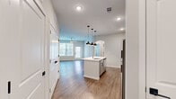Located at 9292 Grand Cordera Pkwy in Colorado Springs, CO, this one-bedroom, one-bathroom unit offers a thoughtfully designed open-concept layout that maximizes its efficient footprint. Wood-style flooring flows throughout the main living areas, complemented by neutral-toned walls and recessed lighting that create a bright, clean aesthetic.

The kitchen serves as a central hub, anchored by a peninsula island with a single-basin sink and pendant lighting overhead. Gray shaker-style cabinetry with black hardware lines the walls, paired with light quartz countertops and a herringbone tile backsplash. Stainless steel appliances, including a refrigerator, electric range, built-in microwave, and dishwasher, complete the space. The kitchen opens directly into the living area, which features a ceiling fan and a glazed door providing access to a private outdoor area, alongside a large window that draws in natural light.

The bedroom is carpeted for comfort, features a ceiling fan, and includes a closet for storage. The bathroom offers a tub and shower combination with full marble-look tile surround, wood-style flooring, and gray cabinetry above the toilet.