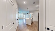 Located at 9292 Grand Cordera Pkwy in Colorado Springs, CO, this one-bedroom, one-bathroom unit offers a thoughtfully designed open-concept layout that maximizes its efficient footprint. Wood-style flooring flows throughout the main living areas, complemented by neutral-toned walls and recessed lighting that create a bright, clean aesthetic.

The kitchen serves as a central hub, anchored by a peninsula island with a single-basin sink and pendant lighting overhead. Gray shaker-style cabinetry with black hardware lines the walls, paired with light quartz countertops and a herringbone tile backsplash. Stainless steel appliances, including a refrigerator, electric range, built-in microwave, and dishwasher, complete the space. The kitchen opens directly into the living area, which features a ceiling fan and a glazed door providing access to a private outdoor area, alongside a large window that draws in natural light.

The bedroom is carpeted for comfort, features a ceiling fan, and includes a closet for storage. The bathroom offers a tub and shower combination with full marble-look tile surround, wood-style flooring, and gray cabinetry above the toilet.