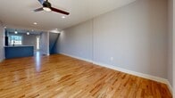 This well-appointed three-story home offers four bedrooms and two full bathrooms across generously proportioned floors. The main level serves as the heart of the home, featuring an open-plan kitchen and living area with warm hardwood flooring, recessed lighting, and a ceiling fan. The kitchen is equipped with slate-blue shaker cabinetry, a farmhouse sink, stainless steel appliances including a dishwasher and range, a peninsula with pendant lighting, and a classic white subway tile backsplash. A second living room on this level features natural hardwood floors, a tiled fireplace, and recessed lighting, adding a cozy focal point to the space. The lower level includes an additional living area with durable hardwood-style flooring, a wall-mounted mini-split system, and sliding glass doors that open to outdoor greenery. The upper floors host the bedrooms, each finished with plush carpeting, ceiling fans, and ample closet space. The two bathrooms are finished with large-format tile flooring, gray vanities with white countertops, and matte black fixtures, with one bathroom offering a full tub-shower combination. Connecting hallways and staircases flow naturally between levels, giving the home a cohesive and functional layout throughout.