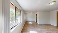 Located at 427 SW 69th St in Gainesville, FL, this single-floor, 2-bedroom, 2-bathroom home offers a functional and comfortable layout. Light wood-style flooring flows consistently throughout the space, creating a clean and cohesive look. The living room is bright and welcoming, featuring dual windows that invite natural light and a sliding glass door that opens to a wooden deck with views of surrounding greenery. A classic six-panel wood front door adds character to the entryway. The galley-style kitchen is equipped with warm wood cabinetry, light countertops, a double sink, and white appliances including a refrigerator and range. An adjacent utility closet provides additional storage. Both bedrooms are comfortably sized, each featuring ceiling fans with lights and closets — one bedroom includes a double bi-fold door closet. The primary bedroom is notably spacious. The primary bathroom offers a dual-sink vanity with wood cabinetry and a tiled shower, while the second bathroom includes a full tub-shower combination with white tile surround. A hallway connects the rooms efficiently, and two closets throughout the home offer practical storage. The overall aesthetic is clean, neutral, and move-in ready.