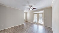 Located at 80 Oak Ave in Mount Pleasant, SC, this single-floor, three-bedroom, two-bathroom home offers a well-designed layout with a blend of modern finishes and practical living spaces. The kitchen is a standout feature, showcasing crisp white cabinetry, quartz countertops, a double-basin sink, subway tile backsplash, and stainless steel appliances including a gas range and built-in microwave. A peninsula counter provides additional workspace and casual seating, opening seamlessly into the dining and living areas. The living and dining spaces feature light-toned luxury vinyl plank flooring that extends through the main areas, creating a cohesive, easy-to-maintain aesthetic. A hallway with crown molding connects the private areas of the home, where the bedrooms feature plush carpet flooring. One bedroom benefits from multiple windows with natural light and a ceiling fan, while the primary bedroom offers direct access to a full bathroom and a generous walk-in closet outfitted with wire shelving for organized storage. The bathrooms are finished with light countertops and vanity mirrors. A dedicated laundry room with full-size washer and dryer hookups and overhead wire shelving adds everyday convenience. Throughout, neutral tones and clean lines contribute to a bright, move-in-ready atmosphere.