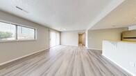 Located at 1307 Impala Dr, Unit D in Norfolk, Nebraska, this single-floor, 2-bedroom, 1-bathroom unit delivers a clean, modern aesthetic throughout. The spacious living room features light-toned luxury vinyl plank flooring, neutral gray walls, a textured ceiling, and a sliding glass door flanked by a window — allowing natural light to fill the space while providing outdoor views of the surrounding neighborhood. The kitchen is thoughtfully designed with white cabinetry, warm butcher block countertops, stainless steel appliances including a refrigerator and range, and a peninsula with a built-in sink and seating overhang — ideal for casual dining. A skylight-style ceiling fixture adds brightness to the kitchen area. Both bedrooms are carpeted and generously proportioned, with the primary bedroom offering ample square footage and a closet. The second bedroom also includes a closet and a window for natural light. The full bathroom features a tub-shower combination, a white vanity with storage, and hard-surface flooring consistent with the rest of the home. A dedicated laundry room houses a full-size washer and dryer alongside the water heater, adding everyday convenience. The unit's cohesive neutral palette and updated finishes create a clean, move-in-ready environment.