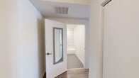 Located on N Wells Street in Chicago's vibrant Old Town neighborhood, this modern 2-bedroom, 2-bathroom residence offers a thoughtfully designed single-floor layout. The open-concept kitchen and living area serves as the heart of the home, anchored by a large center island with a white quartz countertop and undermount sink. Dark wood cabinetry, light blue subway tile backsplash, and a full suite of stainless steel appliances — including a gas range, microwave, and French door refrigerator — give the kitchen a sleek, contemporary feel. Hardwood-style flooring flows throughout the living areas, complementing the clean white walls and modern finishes. The living room opens directly to a private balcony through sliding glass doors, offering views of the Chicago skyline and surrounding greenery. Both bedrooms are well-proportioned, with the primary bedroom featuring direct access to an en-suite bathroom and a spacious closet with built-in wire shelving. The second bedroom benefits from a large window with city views. Both bathrooms are finished with dark wood vanities, white quartz counters, grey tile flooring, and full tub-shower combinations clad in large-format marble-look tile. A dedicated closet provides additional storage throughout the residence.