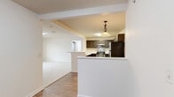 Located at 5000 Stein Dr in Cranberry Township, PA, this well-appointed single-floor home offers three bedrooms, two bathrooms, and a thoughtfully designed layout. The open-concept kitchen and living area serves as the heart of the home, where a U-shaped kitchen is outfitted with dark shaker-style cabinetry, stainless steel appliances including a refrigerator, range, microwave, and dishwasher, and light countertops. A peninsula with a breakfast bar connects seamlessly to the living room, which features wood-look flooring and flows into carpeted spaces beyond. The primary bedroom is generously sized, boasting vaulted ceilings, a large multi-pane window, and a door to an outdoor area, filling the room with natural light. It is complemented by a walk-in closet with built-in wire shelving and a private en-suite bathroom featuring a wide vanity with dark cabinetry, a well-lit mirror, and a tub/shower combination. The two additional bedrooms offer comfortable dimensions, carpeted floors, and windows with natural light. The second bathroom mirrors the same clean, consistent design. Two hallways and two closets provide ample circulation and storage throughout this practical and attractive home.