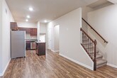 Located at 15109 23 Mile Rd in Shelby Township, Michigan, this multi-level home spans three floors and offers a thoughtfully designed interior with contemporary finishes throughout. The main living level showcases durable wood-look flooring that flows seamlessly from the open living area into the kitchen. The kitchen is well-equipped with rich dark espresso cabinetry, granite countertops, a central island, and a full suite of stainless steel appliances, including a refrigerator, electric range, microwave, and dishwasher. A staircase with an elegant dark wood banister and decorative wrought iron balusters connects the floors, adding a refined architectural touch. Recessed lighting throughout the main level provides a clean, modern ambiance. Upper-level rooms feature soft carpeting and windows with vertical blinds that bring in natural light, creating comfortable, versatile spaces. A full bathroom on the upper level is finished with large-format tile surrounding the soaking tub, a granite-top vanity with dark cabinetry, and tile flooring. The lower level includes a finished room with wood-look flooring and a window, suitable for a variety of uses, as well as an attached garage with an automatic door opener, offering secure and convenient parking.
