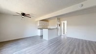 Located at 128 S Bella Vista St in Anaheim, CA, this one-bedroom, one-bathroom unit offers a well-designed, single-floor layout with a clean, modern aesthetic. The open-concept living and kitchen area is anchored by light gray luxury vinyl plank flooring that runs throughout, complemented by textured ceilings and a ceiling fan. A peninsula-style kitchen features white cabinetry, granite countertops, a stainless steel sink, and appliances, creating a functional and stylish cooking space that flows seamlessly into the living area. A wall-mounted HVAC unit provides climate control in the living space. The spacious bedroom is carpeted and benefits from natural light through a wide window, along with a ceiling fan for added comfort. A dedicated walk-in closet with built-in shelving and hanging rods offers generous storage. The bathroom is bright and clean, finished in white with a vanity cabinet, mirror with overhead lighting, and a full shower-tub combination with a window providing natural light. The unit's neutral color palette and updated finishes throughout contribute to a fresh, move-in-ready ambiance.
