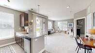 Located in Dublin, Ohio, this well-appointed one-bedroom, one-bathroom residence offers a thoughtfully designed layout across a single floor. The open-concept kitchen and living area form the heart of the home, creating a seamless flow ideal for everyday living and entertaining. The kitchen is outfitted with rich, dark wood cabinetry, granite countertops, a white subway tile backsplash, and black appliances including a range, refrigerator, and built-in microwave. A peninsula with bar seating connects the kitchen to the living area, which is finished with plush carpet and multiple large windows that flood the space with natural light and offer pleasant outdoor views. The bedroom is a comfortable retreat featuring carpet flooring, natural light from dual windows, and direct access to a generously sized walk-in closet equipped with extensive wire shelving and hanging rods for ample storage. The bathroom features a wide granite-topped vanity with dark wood cabinetry, a large framed mirror, and a glass-enclosed shower-tub combination. Neutral gray tones and consistent finishes throughout lend the space a cohesive, modern aesthetic.