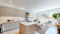 Located in San Diego's vibrant 92103 neighborhood, this thoughtfully designed residence offers two bedrooms and one bathroom across a single, efficiently laid-out floor. The open-concept kitchen and living area serves as the heart of the home, featuring light wood-grain cabinetry extending to the ceiling, white quartz countertops, stainless steel appliances, and a central island that doubles as a casual dining and prep space. Light wood flooring runs throughout, lending warmth and visual continuity.

The living area is bathed in natural light through oversized windows that frame views of surrounding mature trees, creating a bright and airy atmosphere. The bedroom is a serene retreat with a sliding closet, light-toned walls, and wood flooring, maintaining the home's consistent modern aesthetic. The second bedroom offers flexibility as a guest room or home office.

The bathroom is finished in a clean, contemporary style with a wood-front vanity, white quartz countertop, and light flooring. A hallway connects the main living spaces, keeping the layout organized and functional. Throughout, the design prioritizes a neutral, minimalist palette accented by natural materials, resulting in a cohesive and calming living environment well-suited to San Diego's sunny lifestyle.