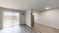 This single-floor residence at 12 Meadow Rd in Pennsville, NJ, offers a clean, modern interior with thoughtfully updated finishes throughout. The open living area is bright and airy, featuring light-toned hardwood-style flooring that flows seamlessly from room to room. A sliding glass door with vertical blinds leads to a private balcony, allowing natural light to fill the space, while a wall-mounted air conditioning unit ensures year-round comfort. A baseboard heating system is also present for efficient warmth. The kitchen is a clear highlight, showcasing rich, dark wood cabinetry with sleek bar-pull hardware, marble-look stone countertops, a classic white subway tile backsplash, and stainless steel appliances including an electric range with overhead ventilation. Ample cabinet storage makes this kitchen as functional as it is stylish. The bathroom features a full tub-and-shower combination elegantly lined with crisp white subway tile from floor to ceiling, paired with clean white fixtures for a timeless, polished look. Throughout the unit, neutral gray-toned walls and white trim create a fresh, cohesive aesthetic that is both modern and versatile. The layout, as seen in the dollhouse view, is compact yet well-organized, making efficient use of every area available.