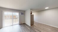 This single-floor residence at 12 Meadow Rd in Pennsville, NJ, offers a clean, modern interior with thoughtfully updated finishes throughout. The open living area is bright and airy, featuring light-toned hardwood-style flooring that flows seamlessly from room to room. A sliding glass door with vertical blinds leads to a private balcony, allowing natural light to fill the space, while a wall-mounted air conditioning unit ensures year-round comfort. A baseboard heating system is also present for efficient warmth. The kitchen is a clear highlight, showcasing rich, dark wood cabinetry with sleek bar-pull hardware, marble-look stone countertops, a classic white subway tile backsplash, and stainless steel appliances including an electric range with overhead ventilation. Ample cabinet storage makes this kitchen as functional as it is stylish. The bathroom features a full tub-and-shower combination elegantly lined with crisp white subway tile from floor to ceiling, paired with clean white fixtures for a timeless, polished look. Throughout the unit, neutral gray-toned walls and white trim create a fresh, cohesive aesthetic that is both modern and versatile. The layout, as seen in the dollhouse view, is compact yet well-organized, making efficient use of every area available.