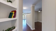 Located at 808 Hawthorne Ln in Charlotte's vibrant 28204 corridor, this single-floor unit offers a thoughtfully designed layout that maximizes every square foot. The open-concept living and kitchen area serves as the heart of the space, showcasing rich dark hardwood flooring that flows seamlessly throughout. The kitchen is a standout feature, equipped with a full suite of stainless steel appliances — including a French door refrigerator, electric range, built-in microwave, and dishwasher — complemented by rich espresso-toned cabinetry, a subway tile backsplash, and a dark granite-topped island with pendant lighting overhead. Track lighting adds additional illumination and a contemporary touch to the culinary space. A ceiling fan with light fixture anchors the living area, which benefits from natural light streaming in through large glass doors that open to an outdoor space. The bathroom is well-appointed with full-surround warm-toned tile, a soaking tub and shower combination with a curved curtain rod, and brushed nickel fixtures. Clean white walls, crisp white trim, and a neutral color palette throughout create a bright, cohesive ambiance well-suited for modern urban living.