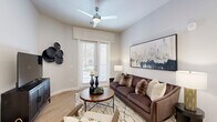 Located in Orlando, FL, this well-appointed 2-bedroom, 2-bathroom single-story residence offers a thoughtfully designed open-concept floor plan with modern finishes throughout. Light wood-style flooring flows seamlessly across the living, dining, and kitchen areas, creating a cohesive and airy atmosphere. The living room features a ceiling fan, large windows with blinds, and a glass door that opens to the private patio, filling the space with natural light. The kitchen is equipped with stainless steel appliances, white cabinetry, recessed lighting, and a generous island with seating — perfect for both casual dining and entertaining. A separate dining area completes the open social zone. The primary bedroom is a comfortable retreat with large windows and direct access to a spacious walk-in closet with built-in shelving. The ensuite bathroom features large-format tile flooring, a sleek vanity, and a glass-enclosed walk-in shower with white subway tile and a built-in niche. The second bedroom is equally well-sized with ample natural light. Additional highlights include abundant closet storage, a dedicated laundry area, a pantry, and two hallways that enhance the functional flow of the home.