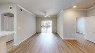 Located at 5720 Forest Park Rd in Dallas, TX, this single-floor residence offers three bedrooms and two bathrooms within a well-organized, efficiently designed layout. The living area is a bright, open space finished with light wood-look flooring and crown molding, anchored by a ceiling fan and a sliding glass door that invites natural light and provides views of the outdoor surroundings. The kitchen features a wraparound peninsula with a white countertop that opens to the living area, complemented by white cabinetry, a stainless steel refrigerator, and an electric cooktop — creating a functional and clean workspace. Each of the three bedrooms showcases the same warm wood-look flooring, neutral wall tones, ceiling fans, and windows with outdoor views, lending a consistent and airy feel throughout. The primary bedroom offers a comfortable, well-proportioned retreat. Both bathrooms are finished with tile flooring, white cabinetry, and tub-shower combinations, maintaining a clean, neutral aesthetic. A dedicated closet provides additional storage. The overall design emphasizes a clean, move-in-ready palette with neutral tones, consistent flooring, and practical layouts suited for everyday living in the heart of Dallas.