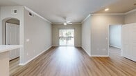 Located at 5720 Forest Park Rd in Dallas, TX, this single-floor residence offers three bedrooms and two bathrooms within a well-organized, efficiently designed layout. The living area is a bright, open space finished with light wood-look flooring and crown molding, anchored by a ceiling fan and a sliding glass door that invites natural light and provides views of the outdoor surroundings. The kitchen features a wraparound peninsula with a white countertop that opens to the living area, complemented by white cabinetry, a stainless steel refrigerator, and an electric cooktop — creating a functional and clean workspace. Each of the three bedrooms showcases the same warm wood-look flooring, neutral wall tones, ceiling fans, and windows with outdoor views, lending a consistent and airy feel throughout. The primary bedroom offers a comfortable, well-proportioned retreat. Both bathrooms are finished with tile flooring, white cabinetry, and tub-shower combinations, maintaining a clean, neutral aesthetic. A dedicated closet provides additional storage. The overall design emphasizes a clean, move-in-ready palette with neutral tones, consistent flooring, and practical layouts suited for everyday living in the heart of Dallas.