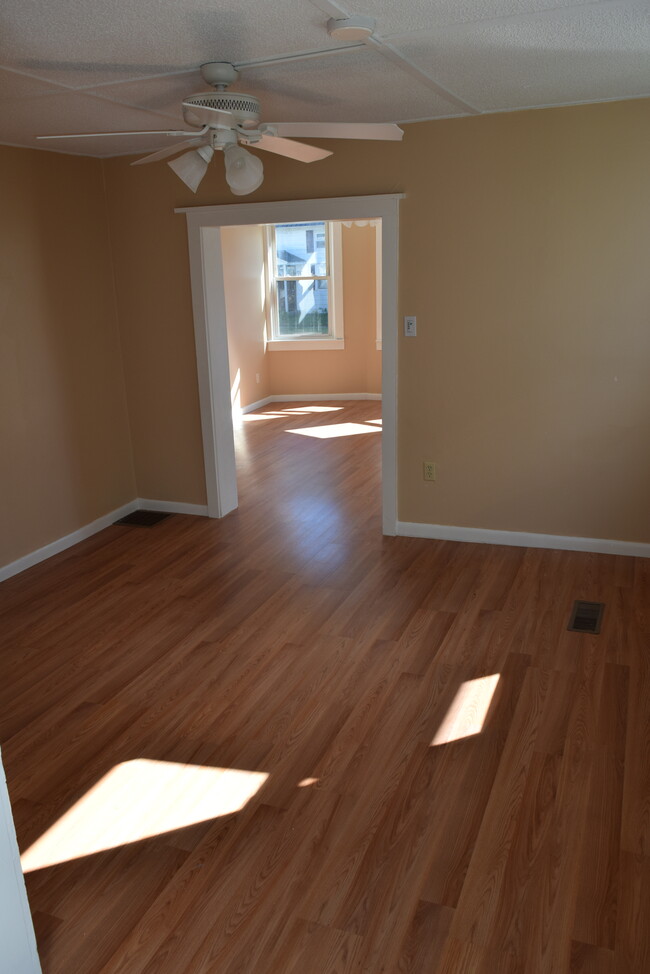 Dining room with space for entertaining. Overhead lighting with a ceiling fan. - 8 Grand Street