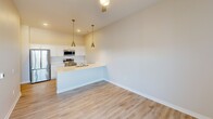 This contemporary 500 square foot apartment in Cedar Rapids, Iowa, offers a thoughtful blend of style and functionality. The open-concept floor plan maximizes the use of space, creating a seamless flow between the living areas. The kitchen is a standout feature, boasting white cabinetry, a subway tile backsplash, and stainless steel appliances, including a microwave mounted above the range. Two pendant lights add a touch of elegance over the kitchen counter.

The living area is graced with wood-look vinyl flooring, providing durability and warmth. Large windows flood the space with natural light and offer views of the surrounding cityscape. The bedroom, an impressive 450 square feet, features plush carpeting and a spacious closet with sliding doors, ensuring ample storage.

The bathroom is equipped with modern fixtures, including a combination tub and shower with a curved shower rod. The apartment's neutral color palette, predominantly in shades of white and beige, creates a bright and airy ambiance throughout. This well-designed space efficiently accommodates all the necessities of urban living within its compact 500 square foot layout.