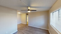 Located at 1038 N 48th St in Phoenix, Arizona, this single-floor residence offers a clean, updated interior with a cohesive design throughout. The living areas are finished with durable wood-look plank flooring in a warm neutral tone, complemented by crisp white baseboards and smooth, neutral-painted walls. Ceiling fans are installed in the main living spaces, providing both comfort and overhead lighting, while textured ceilings add a classic touch to the aesthetic. Natural light enters through windows fitted with horizontal blinds, brightening the rooms and creating an inviting atmosphere. The kitchen has been thoughtfully renovated and features white shaker-style cabinetry, gray quartz-look countertops, and a classic white subway tile backsplash with dark grout accents. Stainless steel appliances, including a refrigerator and range, are complemented by a stainless undermount sink with a brushed gold faucet, and track lighting overhead ensures excellent task illumination. The bathroom is well-appointed with a full tub and shower combination, brushed nickel fixtures and hardware, and clean white surroundings. Throughout the space, the design prioritizes functionality and a modern, neutral palette that offers a versatile backdrop for a variety of interior styles.