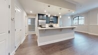 Located at 603 Amelia St in Fredericksburg, VA, this single-floor residence offers a thoughtfully designed layout with contemporary finishes throughout. The kitchen is a standout feature, showcasing bold navy-blue cabinetry paired with white quartz countertops, stainless steel appliances, and a large island with pendant lighting overhead. Light wood-tone flooring runs through the kitchen and extends into the open living area, which is adorned with crown molding, recessed lighting, and a ceiling fan. Multiple windows allow natural light to fill the space, creating a bright and welcoming ambiance.

The bedrooms are finished with plush neutral carpeting and ceiling fans, each featuring windows dressed with blinds—one notably displaying an arched window design that adds architectural character. The bathrooms mirror the kitchen's design aesthetic with navy cabinetry, white countertops, dark wood-look tile flooring, and tub-shower combinations with clean white subway tile surrounds and polished chrome fixtures.

A dedicated utility room houses a stacked washer and dryer alongside a water heater, providing practical functionality. Overall, the space presents a cohesive, modern palette of neutral tones and quality finishes throughout.