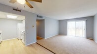 Located at 3303 W Willow Knolls Dr in Peoria, IL, this single-floor unit offers a straightforward, functional layout with a neutral color palette of soft gray walls and white trim throughout. The entry area features light wood-style flooring and a ceiling fan overhead, opening into a combined living and dining space. This generously sized area transitions from hard flooring to plush carpeting, with a sliding glass door on one end providing natural light and access to an outdoor area. A ceiling fan with a wood-blade accent adds a casual touch.

The kitchen is efficiently arranged with white cabinetry featuring bronze hardware, white countertops, a double basin sink, and white appliances including a refrigerator, electric range, built-in microwave, and dishwasher. Light wood-style flooring continues underfoot.

The bedrooms are carpeted and finished in the same soft gray tones. One bedroom features dual windows with blinds on adjacent walls, filling the space with natural light and a ceiling fan. Additional bedrooms offer quiet, understated settings.

Two bathrooms serve the unit; one includes a vanity with white cabinetry and a tub-shower combination, while a second half-bath features striped wallpaper accents. Light wood-style flooring carries through both bathrooms.