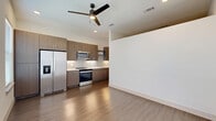 Located at 4040 Valley View Ln in Farmers Branch, TX, this thoughtfully designed one-bedroom, one-bathroom unit offers a modern aesthetic with clean lines and contemporary finishes throughout. The open-concept kitchen and living area serves as the heart of the home, featuring warm wood-toned cabinetry, white quartz countertops, a sleek undermount sink, and a full suite of stainless steel appliances including a range, microwave, and refrigerator. A stylish subway tile backsplash and recessed lighting complete the kitchen's polished look, while wood-style flooring flows through the main living space. A ceiling fan enhances comfort in the combined living area. The hallway connects the main living space to the private quarters, with two closets providing generous storage. The bedroom is finished with soft carpeting, a ceiling fan, built-in shelving, and a sliding barn-style closet door, offering a cozy and organized retreat. The bathroom features a marble-accented tub and shower combination with glass enclosure, a floating wood vanity with a white countertop, and wood-style flooring. A dedicated utility room accommodates in-unit laundry needs. Crisp white walls and abundant recessed lighting throughout lend the space a bright, contemporary feel.