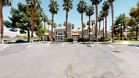 This single-story commercial property presents a polished and professional exterior designed to make a strong first impression. The building features a classic stucco finish in warm earth tones, accented by a decorative tile roof and a distinctive two-tone façade that adds architectural character. A neatly lined walkway flanked by well-maintained hedges and desert-friendly landscaping leads to an inviting entrance fitted with elegant French doors, conveying both accessibility and style.

The property is set within a generously sized parking area, offering convenient accommodation for visitors and staff alike. Towering palm trees line the perimeter, lending a resort-like atmosphere and providing natural shade across the grounds. The combination of lush greenery, manicured shrubs, and desert landscaping reflects thoughtful exterior upkeep suited to the arid climate.

Large windows on the front façade allow natural light to filter into the interior, contributing to an open and welcoming ambiance. The overall design balances functional commercial architecture with appealing aesthetic details, making this property well-suited for a variety of professional or service-oriented uses. The single-floor layout promotes ease of navigation throughout the space, while the building's prominent positioning and visible signage ensure strong visibility from the surrounding area.