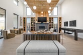 Located at 4107 Laster Ln in Caldwell, Idaho, this single-floor community facility spans a generous footprint designed to serve as a premium amenity hub. The space is defined by soaring ceilings, warm natural wood ceiling panels, and light luxury vinyl plank flooring that runs seamlessly throughout.

The expansive fitness center is a standout feature, bathed in abundant natural light from floor-to-ceiling black-framed windows overlooking the surrounding neighborhood. It is comprehensively equipped with treadmills, ellipticals, cable machines, a dumbbell rack, a weight bench, and a spin bike. Full-length mirrors line the walls, enhancing the sense of space.

An adjacent dedicated exercise studio offers a clean, open layout with mirrored walls, a wall-mounted TV, yoga mats, resistance bands, and suspension trainers — ideal for group classes or individual training sessions.

The two living areas deliver a refined, lounge-like atmosphere. One features soaring double-height ceilings, floor-to-ceiling windows with outdoor views, warm wood shelving, a fireplace, and comfortable seating arrangements. The other includes a billiards table, built-in bookshelves, and curated décor. A bar-height counter with seating and a mounted TV completes the social space, making it well-suited for community gatherings.