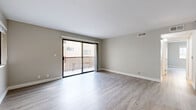 Located at 6600 Woodley Ave in Los Angeles, CA, this 3-bedroom, 2-bathroom unit offers a well-organized single-floor layout designed for comfortable living. The combined dining and living area is bright and open, featuring light wood-style flooring and neutral toned walls that create a clean, modern aesthetic. Sliding glass doors lead directly to a private balcony, bringing in natural light and outdoor views. The galley-style kitchen is well-appointed with rich dark wood cabinetry, stone-look countertops, and stainless steel appliances including a gas range, microwave, and refrigerator. A hallway connects the three bedrooms, each finished with the same light flooring and neutral palette. The primary bedroom includes a ceiling fan and a dedicated closet, while each bedroom benefits from its own closet for ample storage. Both bathrooms feature clean white tub-shower combinations, wood-toned vanities with brushed nickel hardware, and light flooring that ties the space together cohesively. The hallway is neatly finished and provides easy access to all rooms. Throughout the unit, consistent finishes and a neutral color scheme give the space a fresh, move-in-ready feel well-suited for daily living in the San Fernando Valley.