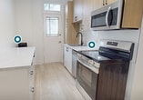 This spacious 81 square meter apartment combines classic charm with modern amenities. The living area showcases beautiful bay windows that flood the space with natural light, complemented by gleaming hardwood floors throughout. The two bedrooms are generously sized, with the primary bedroom offering 21 square meters of space. The single bathroom features a classic black and white tile design, complete with a bathtub and modern fixtures. The kitchen is a highlight, boasting sleek light wood cabinetry, stainless steel appliances, and ample counter space. Vintage cast iron radiators add character while providing efficient heating. The apartment's layout includes three hallways, ensuring easy flow between rooms. High ceilings and crisp white walls contribute to an open, airy feel throughout the space. Located at 120 Wurtemburg, this single-story home perfectly balances period charm with contemporary comfort, making it an ideal urban dwelling.