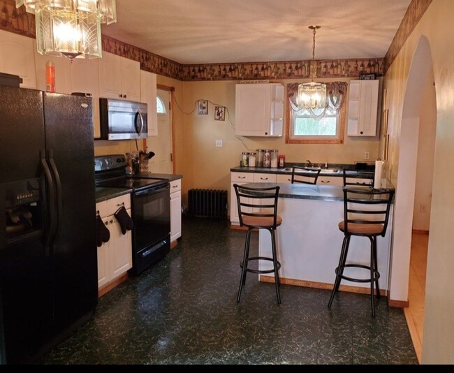 Kitchen. Chandelier has been replaced with bulb light and walls have been repainted white. - 11 Cypress St