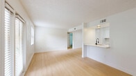 Located at 1799 CR-19A in Eustis, Florida, this single-story 2-bedroom, 2-bathroom residence offers a clean, modern aesthetic throughout. Light wood-style flooring flows seamlessly across every room, complementing the crisp white walls and textured ceilings that define the interior's bright, airy character.

The open living and dining area is bathed in natural light, thanks to a large window and a glass-paneled door that opens to the outdoors, offering pleasant views of the surrounding greenery. Adjacent to the living area, a pass-through counter connects to the galley-style kitchen, which is thoughtfully designed with white shaker cabinetry, light stone countertops, and a full suite of stainless steel appliances including a range, microwave, dishwasher, and refrigerator.

Both bedrooms are comfortably sized and feature ceiling fans with light fixtures, natural window views, and dedicated closet space. The primary bedroom includes a walk-in closet and direct access to one of the two full bathrooms. Each bathroom is finished with white tile tub-shower combinations, wood-style flooring, and clean, simple fixtures. A utility room and additional closets round out the functional layout, making this an efficient and well-organized living space.