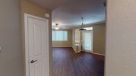 This well-appointed single-floor residence offers a thoughtfully designed layout that balances comfort and functionality. The open living and dining area is anchored by rich, dark hardwood flooring that extends throughout the main living spaces, complemented by warm neutral-toned walls and crown molding. A striking tiled fireplace serves as the focal point of the living room, while ceiling fans provide year-round comfort. Multiple windows dressed with vertical blinds allow generous natural light to fill the space.

The dining area is distinguished by a stylish pendant light fixture, and a welcoming front entry door with sidelight brings additional brightness into the home. The kitchen is equipped with light maple cabinetry, dark granite countertops, stainless steel appliances including a range and over-the-range microwave, and a double sink — all set against light hardwood flooring.

The bedrooms feature plush carpeting, ceiling fans, and ample natural light. One bedroom includes a built-in closet with shelving. The bathroom offers a large vanity with light maple cabinetry, a wide mirror, and a well-lit Hollywood-style light bar. A dedicated laundry room with side-by-side washer and dryer hookups and hardwood flooring rounds out this functional and comfortable home.