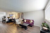 Located at 459 Apartment Court Dr in Baton Rouge, Louisiana, this two-story, one-bedroom, two-bathroom home offers a thoughtfully designed layout spread across two floors. The main level features an open-concept living and dining area with warm hardwood-style flooring, neutral gray walls, and a textured ceiling that adds character to the space. The living area is generously sized, providing ample room for comfortable seating and entertainment. Adjacent to the living space is a functional kitchen equipped with white cabinetry, light countertops, black appliances including a refrigerator and range, a built-in breakfast bar, and a track lighting fixture that brightens the workspace. A window allows natural light to flow in. The upper floor houses the primary bedroom, which offers plush carpeting, a sliding-door closet, and direct access to an en-suite bathroom. The two bathrooms are finished with neutral tile wainscoting, white vanity cabinetry with light countertops, and tub-shower combinations. A dedicated hallway connects the rooms efficiently. Throughout the home, the consistent neutral color palette and clean finishes create a cohesive, move-in-ready aesthetic well suited for comfortable everyday living in Baton Rouge.
