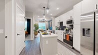 Located at 1015 N Alexander Street in Charlotte's vibrant 28206 corridor, this thoughtfully designed one-bedroom, one-bathroom residence maximizes every inch of its single-floor layout. The open-concept kitchen is a standout feature, showcasing white shaker cabinetry that extends to the ceiling, a bold dark hexagonal tile backsplash, stainless steel appliances including a full-size side-by-side refrigerator and gas range, and a central island with pendant lighting — ideal for both cooking and casual dining. Wood-look flooring flows throughout the main living areas, connecting the kitchen seamlessly to the living room, which is anchored by a teal accent wall and large windows that invite abundant natural light and outdoor views. The bedroom offers plush carpeting, a soothing sage-toned accent wall, access to a closet, and a large window with balcony views, creating a calm, restful atmosphere. The bathroom features wood-look flooring, a white vanity with a bold-framed mirror, matte black fixtures, and a tiled shower. A connecting hallway ties the layout together efficiently, making this residence a polished and functional home in the heart of Charlotte.