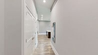 Located at 2118 Creason St in Bowling Green, KY, this well-appointed 2-bedroom, 2-bathroom unit offers a thoughtfully designed single-level layout with modern finishes throughout. Wood-look plank flooring flows seamlessly across all living areas, complementing the neutral gray and sage-toned walls that give the space a clean, contemporary feel.

The open-concept kitchen and living area serves as the heart of the home, featuring a large center island with a double sink, white quartz countertops, dark espresso shaker-style cabinetry with glass-front accents, and stainless steel appliances including a refrigerator, range, and microwave. Pendant lighting above the island adds a refined touch. The adjacent living room opens to a private balcony through sliding glass doors, bringing in abundant natural light and outdoor views. Built-in shelving along one wall provides functional display and storage space.

Both bedrooms are well-sized, each equipped with a ceiling fan and wood-look flooring. The primary bedroom includes access to a dedicated closet with built-in shelving and a rod system. Its en-suite bathroom features a glass-enclosed walk-in shower, a single vanity with white countertop, and wood-look tile flooring. The second bathroom offers a full tub-shower combination and a stylish dark-framed vanity, maintaining the consistent modern aesthetic found throughout the home.