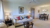 Located at 4251 Strattford Circle in Zanesville, Ohio, this single-story residence offers a well-designed living space with a warm, inviting atmosphere. The living room serves as the heart of the home, showcasing neutral-toned carpeting and soft, light-colored walls that create a bright and airy feel throughout. A ceiling fan is centrally positioned overhead, providing both practical airflow and a finishing touch to the room's layout.

The living area is generously proportioned, offering ample room for comfortable furnishings and everyday living. Warm-toned wood trim accents the doorways, adding a classic architectural detail that complements the overall aesthetic. An open passage leads to an adjacent room, suggesting a connected and functional floor plan that promotes easy movement throughout the home.

Natural light filters into the space, contributing to its welcoming ambiance. The single-floor layout offers convenience and accessibility, making it a practical and comfortable living option. The overall design reflects a straightforward, functional style with tasteful details that create a cohesive and livable environment throughout the home.