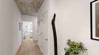Located at 1400 S Wabash Ave in Chicago's South Loop neighborhood, this single-floor residence showcases a modern industrial aesthetic defined by exposed concrete ceilings and light-toned hardwood flooring throughout. Floor-to-ceiling windows are a prominent architectural feature, flooding the living spaces with natural light while framing sweeping views of the Chicago skyline and surrounding cityscape.

The open-concept living area is anchored by expansive glazing on multiple sides, with structural concrete columns adding an industrial character to the space. The kitchen is well-appointed with warm wood cabinetry, stainless steel appliances, and a generous island with seating—ideal for both casual dining and entertaining.

Multiple bedrooms benefit from the same large-format windows, offering city views and ample natural light. The hallway connects the private and shared areas seamlessly, featuring louvered closet doors and clean white walls that contrast with the textured concrete overhead.

Bathrooms are finished in a clean, minimalist style with light wood flooring, white cabinetry, and simple fixtures. Throughout the unit, the interplay of raw concrete, crisp white walls, and warm wood tones creates a cohesive, contemporary urban atmosphere.
