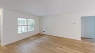Located at 800 Westridge Dr in Phoenixville, PA, this well-appointed single-floor home offers three bedrooms, two bathrooms, and a thoughtfully designed layout. Light-toned hardwood flooring flows throughout the main living areas, complementing the clean white walls and creating a bright, cohesive aesthetic. The combined kitchen and living room serves as the heart of the home, with the kitchen featuring dark granite countertops, gray cabinetry, stainless steel appliances including a refrigerator, range, and microwave, and pendant lighting over a central island. Large windows in the living area invite natural light and offer views of the lush, tree-lined surroundings. The three bedrooms are carpeted for comfort, with the generously sized primary bedroom offering ample closet space. The bathrooms are finished with wood-look flooring and crisp white fixtures. A dedicated laundry room with full-size washer and dryer adds everyday convenience. Outside, the property is set within a well-maintained community featuring manicured lawns and mature trees, providing a peaceful residential environment.