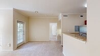This 600 square foot apartment in Cedar Park, Texas, offers a thoughtfully designed living space. The single-story layout features one bedroom measuring 150 square feet and one bathroom. The heart of the home is an open-concept kitchen and living room area, promoting a sense of spaciousness.

The kitchen is equipped with modern stainless steel appliances, including a refrigerator, stove, and built-in microwave. Wood cabinetry and granite countertops add a touch of elegance. Adjacent to the kitchen is a dedicated laundry area, enhancing convenience.

The bedroom boasts plush carpeting and a ceiling fan, with large windows allowing ample natural light. The bathroom features a single vanity with a granite countertop and ample storage space. Throughout the apartment, neutral-toned walls create a bright, airy atmosphere.

Multiple windows in the living area and bedroom offer views of the surrounding greenery, while ceiling fans in both rooms ensure comfort. The apartment's efficient design includes a closet for additional storage. Wood-look flooring in the kitchen and entryway contrasts nicely with the carpeted living spaces, adding visual interest to this compact yet functional home.