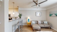 This single-story residence in New Orleans, Louisiana offers a thoughtfully designed layout that maximizes its compact footprint. Wood-style flooring runs throughout the main living areas, complementing a neutral color palette and crown molding details that lend a polished character to the space.

The open-concept living area connects seamlessly to the kitchen via a peninsula counter with bar seating, illuminated by pendant lighting overhead. The kitchen is equipped with stainless steel appliances—including a refrigerator, range, microwave, and dishwasher—paired with white shaker-style cabinetry and granite-look countertops. A ceiling fan with a brushed nickel finish anchors the living room, which receives natural light through a large window.

The bedroom is a calm, comfortable retreat featuring a ceiling fan, a window with blinds and curtain panels, and ample floor space. The full bathroom includes a single-sink vanity with a white countertop, a tub/shower combination, and wood-look tile flooring. A dedicated laundry area with a full-size washer and dryer adds everyday convenience to this efficiently designed New Orleans residence.