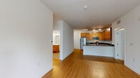 Located at 3821 Greenway Blvd in Roselle, NJ, this two-bedroom, two-bathroom residence offers a thoughtfully designed single-floor layout with a clean, modern aesthetic throughout. The open-concept kitchen and living area serves as the heart of the home, featuring rich warm-toned wood cabinetry, dark granite countertops, stainless steel appliances including a refrigerator, range, microwave, and dishwasher, and a peninsula that doubles as a breakfast bar. Track lighting illuminates the kitchen, while light hardwood-style flooring extends seamlessly through the living area, creating a warm and cohesive atmosphere. The living room is bright and open, benefiting from natural light and providing direct access to an outdoor area through a glass-panel door. The spacious primary bedroom offers a generous footprint with a large window framing views of surrounding greenery. The second bedroom is equally well-appointed with hardwood-style flooring and ample natural light. The bathrooms are finished with white subway tile, including a sleek glass-enclosed walk-in shower. Throughout the home, crisp white walls, clean lines, and consistent flooring contribute to a polished and move-in ready environment.