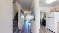 Located at 800 Kingston Ct in Edgewood, Maryland, this two-story, 2-bedroom, 2-bathroom home offers a thoughtfully organized layout spread across two floors. The main level features a welcoming hallway with wood-look flooring that flows throughout, leading to a bright living room with a large sliding glass door that fills the space with natural light and provides outdoor views. The kitchen is equipped with light wood cabinetry, ample counter space, a dishwasher, range, microwave, and a sink with a window — offering both practicality and functionality. A full bathroom on this level conveniently doubles as a laundry room, housing a full-size washer and dryer alongside a tub-shower combination and wood vanity. Upstairs, the carpeted staircase leads to two bedrooms and a hallway. The primary bedroom is a comfortable retreat featuring hardwood-style flooring, natural light from a window, a closet, and direct access to the upper hallway. The secondary bedroom mirrors this cozy aesthetic with patterned window treatments and warm neutral tones. Decorative artwork is displayed throughout, lending the home a curated, welcoming ambiance. The consistent use of light tones and wood-look flooring across both levels creates a cohesive and inviting atmosphere throughout.